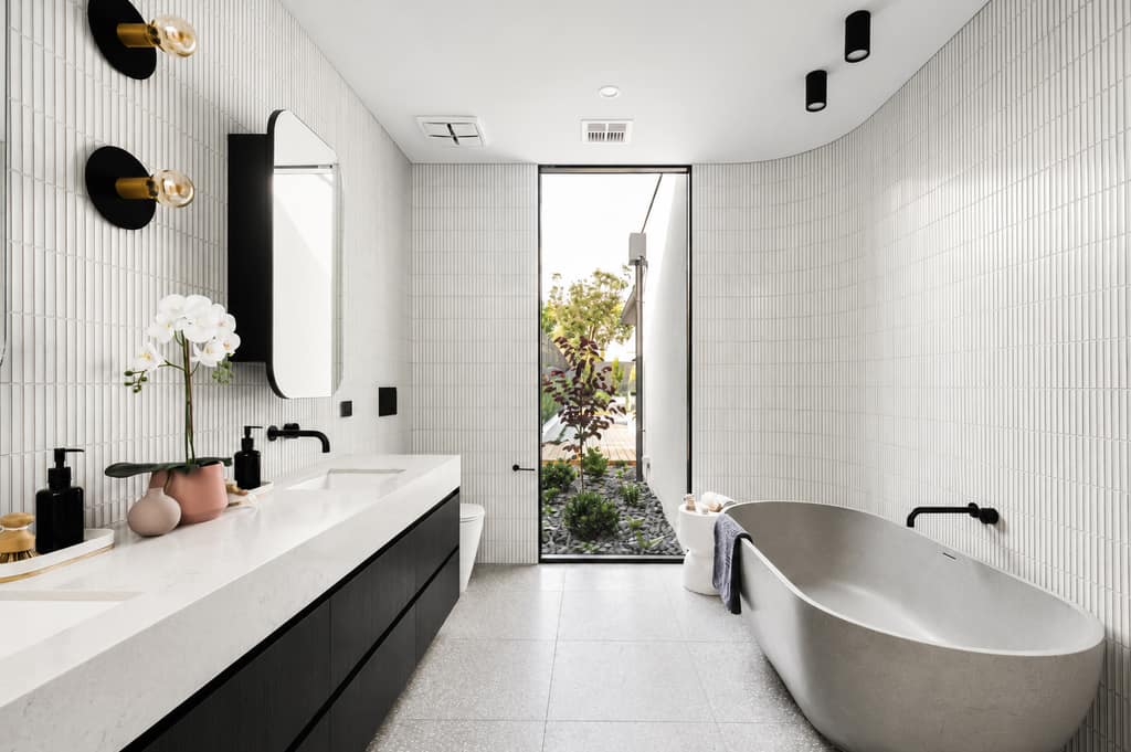 Custom vanity with stone benchtop and freestanding bath in a Melbourne bathroom