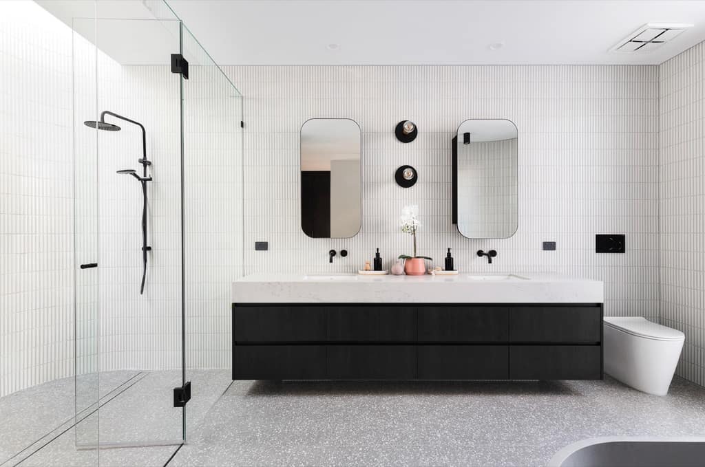 Black floating double vanity with white finger-tile walls and twin mirrors